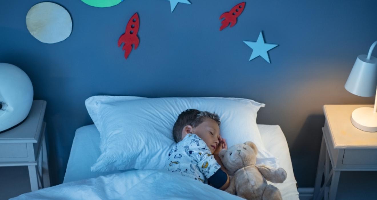 picture of a child asleep in a blue space themed bedroom