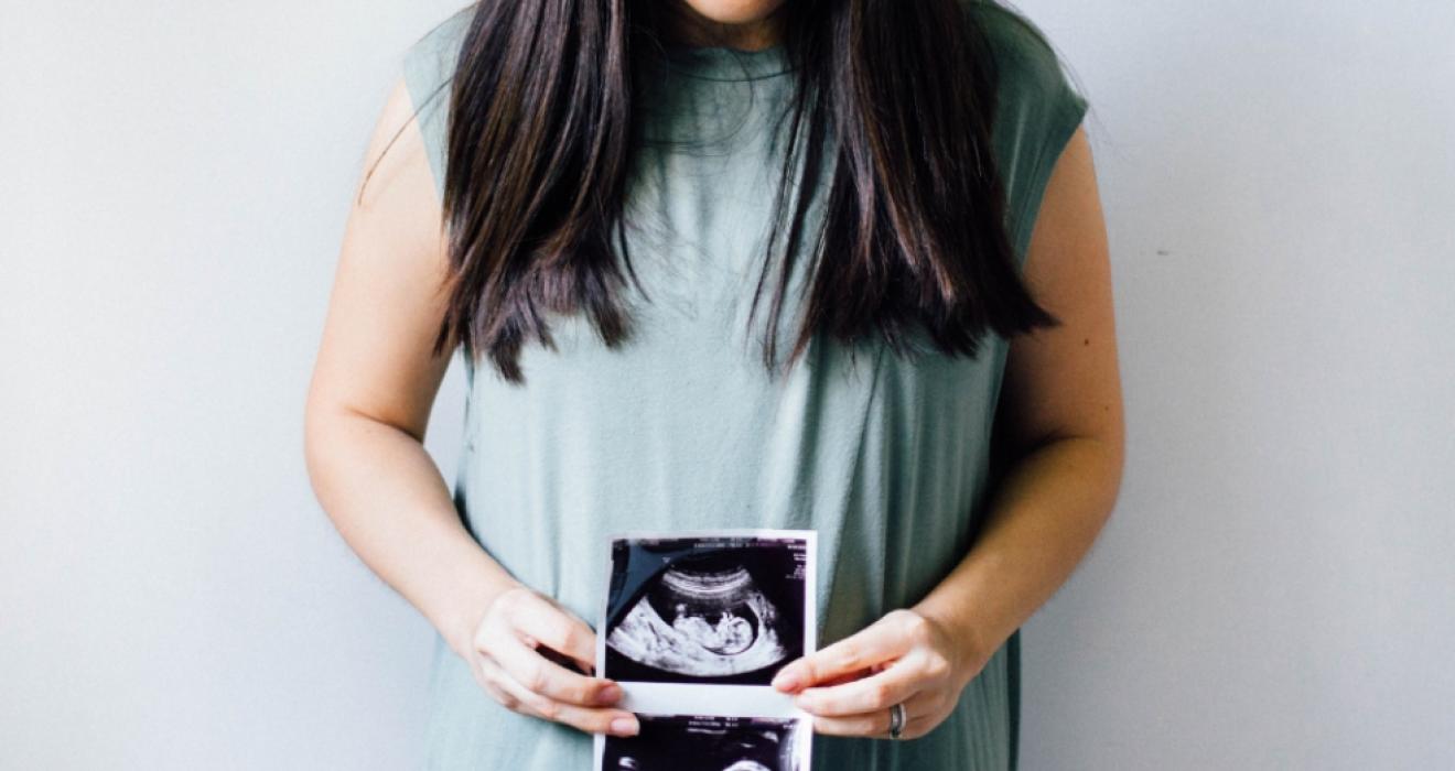 picture of a pregnant woman holding a scan photo