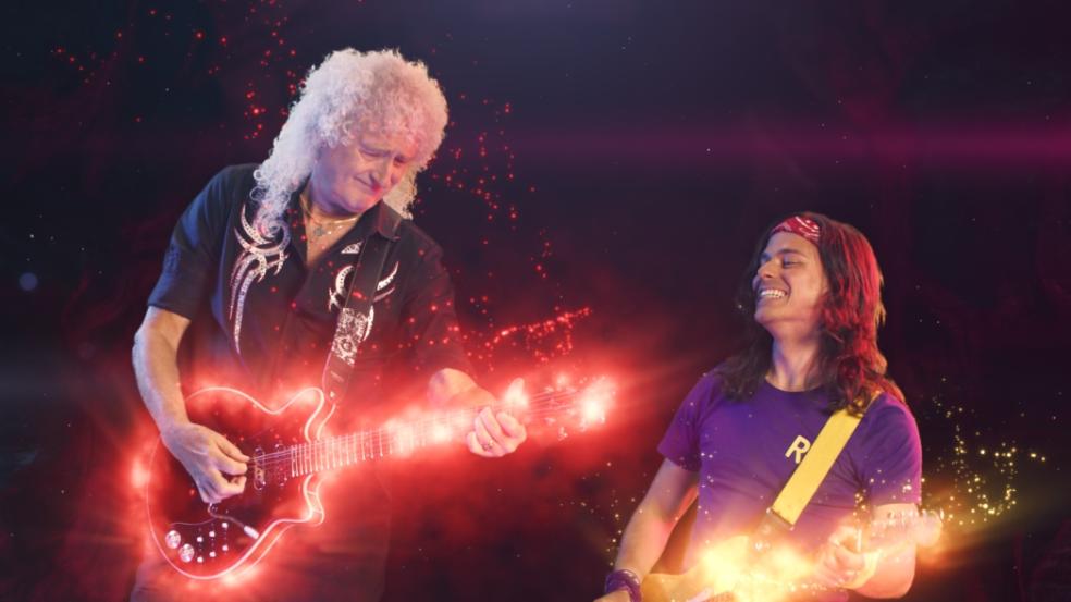 Picture of brian may playing guitar with andy and the band