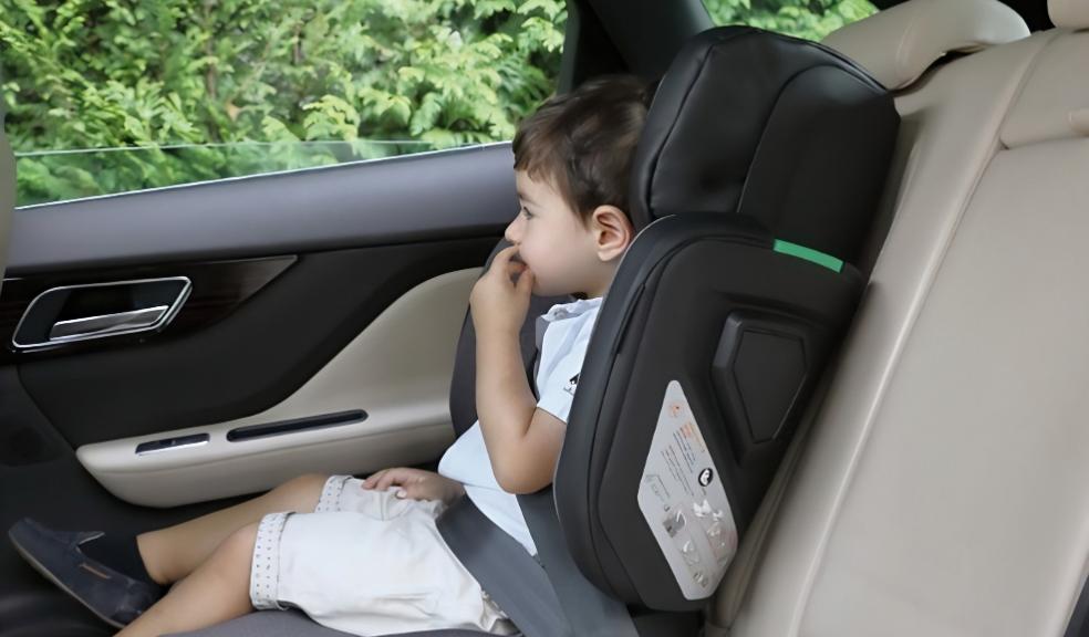 picture of a child using the multifold car seat in the back of a car