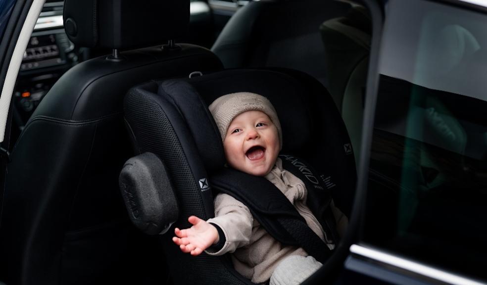 picture of a happy baby in a Axkid Minikid rear facing car seat