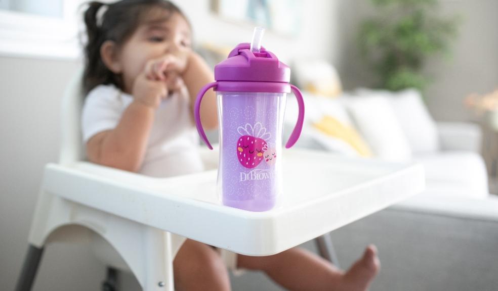 picture of a toddler in a high chair with a Dr Browns strawberry cup with a straw and lid