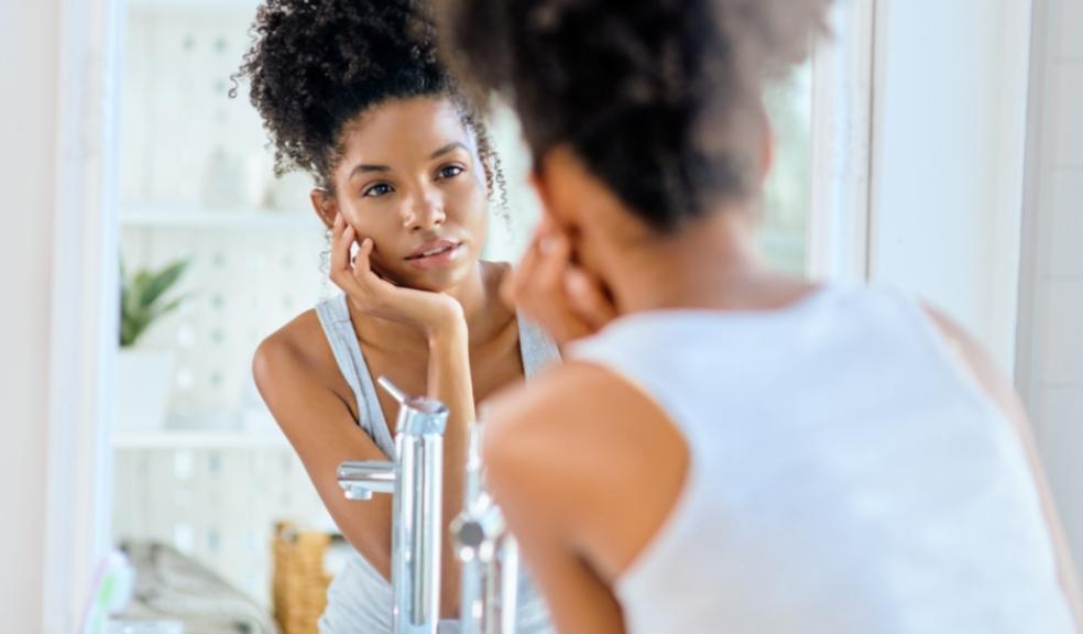 picture of a teen doing a skincare routine looking in a mirror