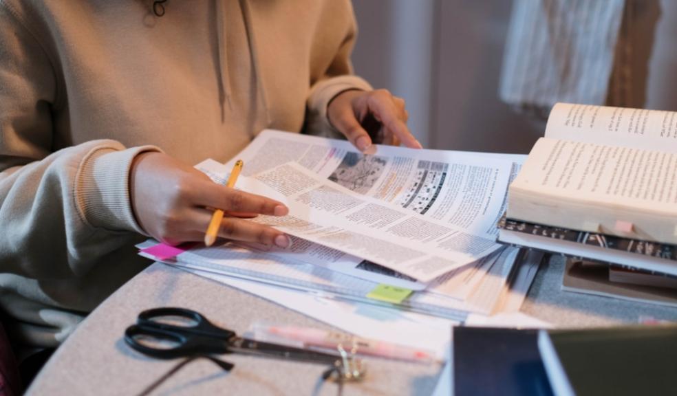 a child revising at home for exams in a calm way with resources on the table picture of a child revising at home for exams in a calm way with resources on the table