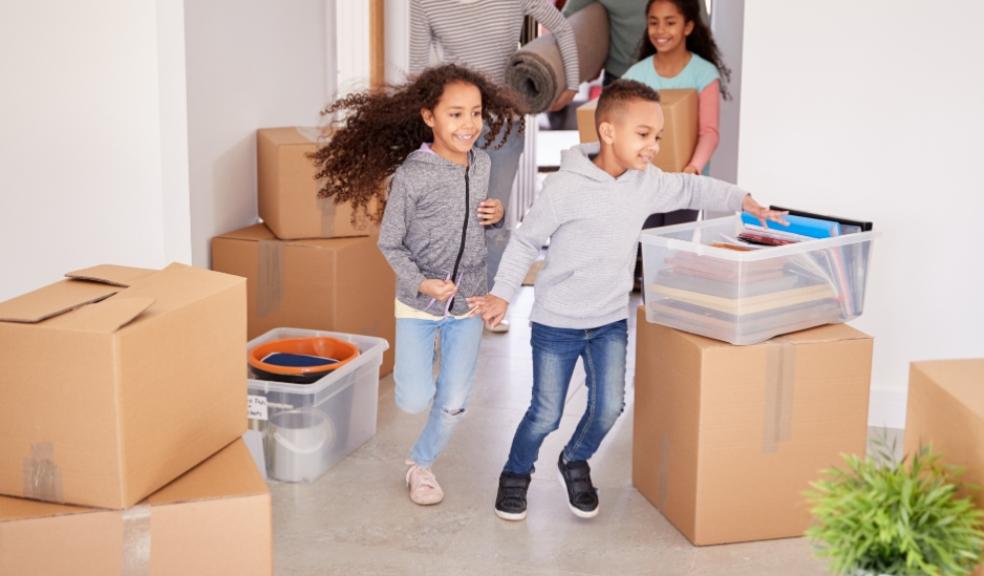 a family moving into a new house with packing boxes around them picture of a family moving into a new house with packing boxes around them