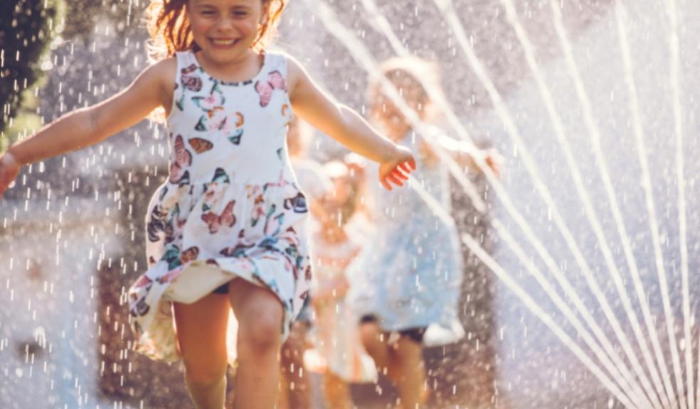 a happy child running through a sprinkler on a hot summer day in the garden picture of a happy child running through a sprinkler on a hot summer day in the garden