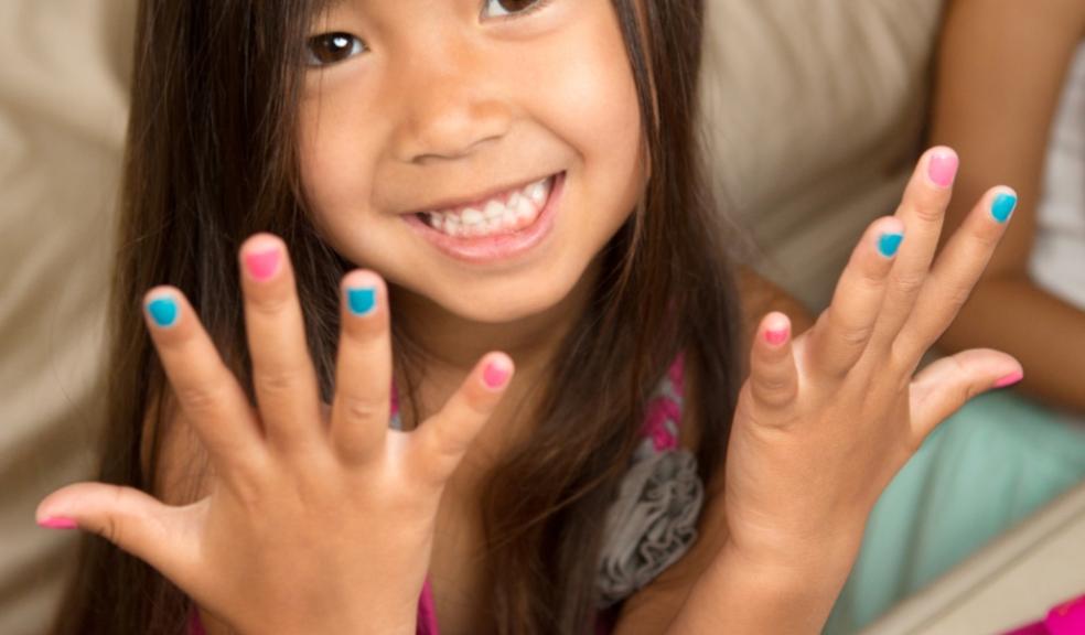 a happy child showing off her nails that are painted with non toxic colourful polish picture of a happy child showing off her nails that are painted with non toxic colourful polish
