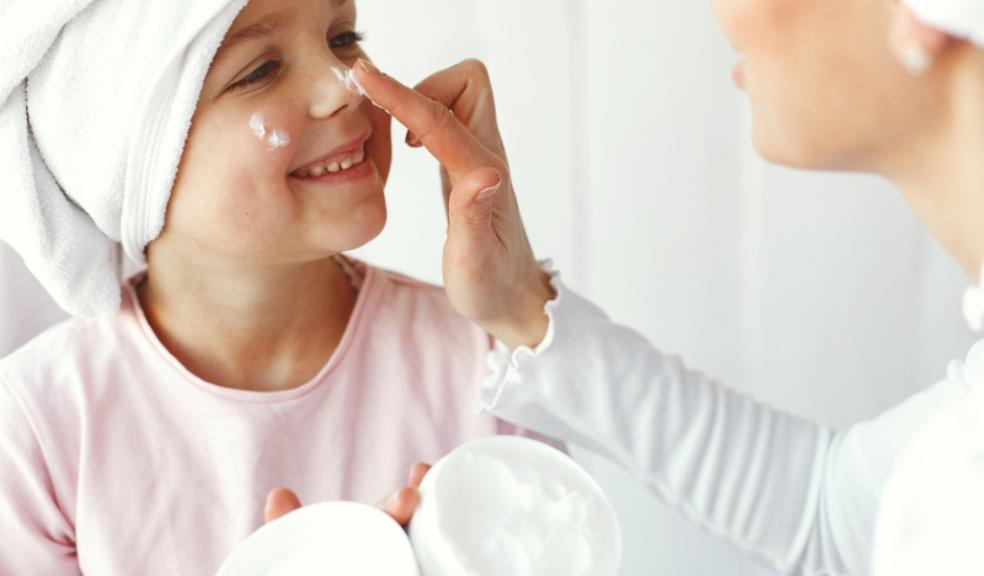 a happy child who suffers from dry skin having lotion put on her face picture of a happy child who suffers from dry skin having lotion put on her face