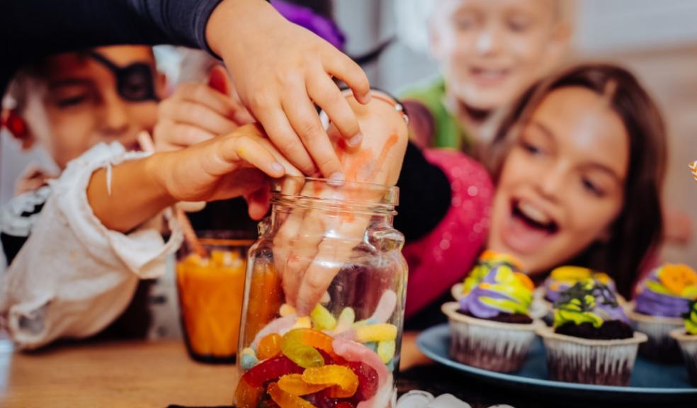 picture of a happy family digging into a sweet jar at Halloween