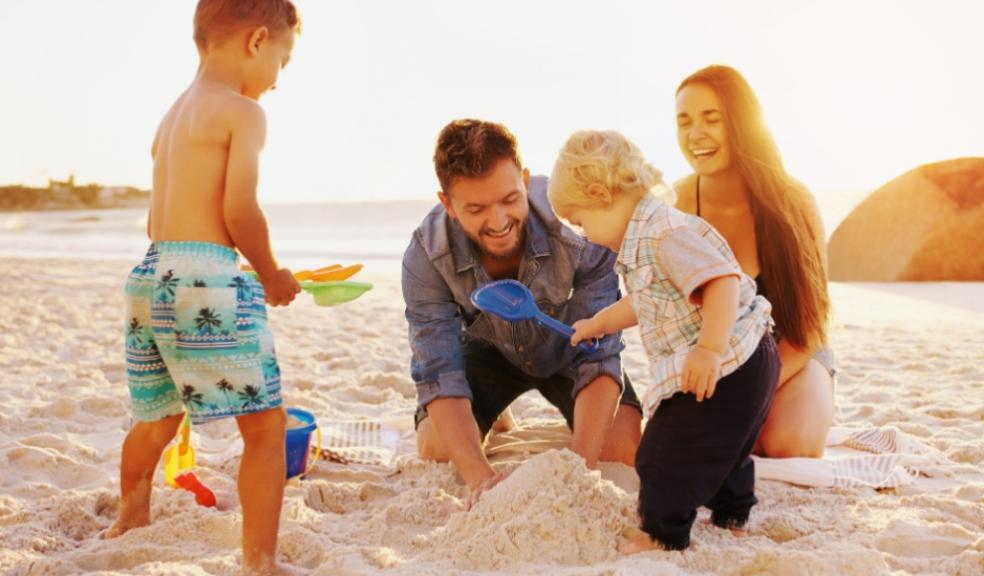 picture of a happy family on a beach building a sandcastle whilst on holiday