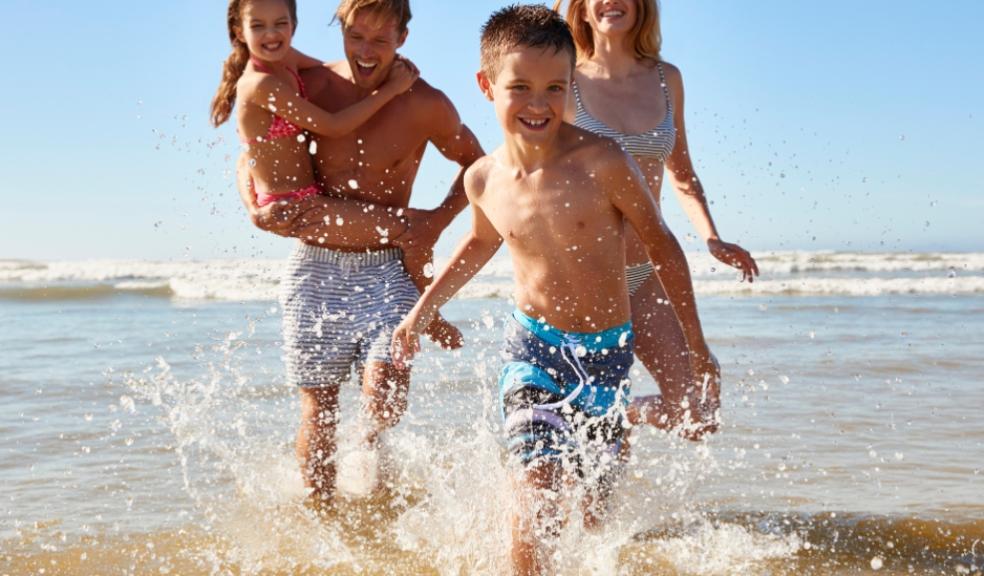 picture of a happy family running through the sea whilst on holiday