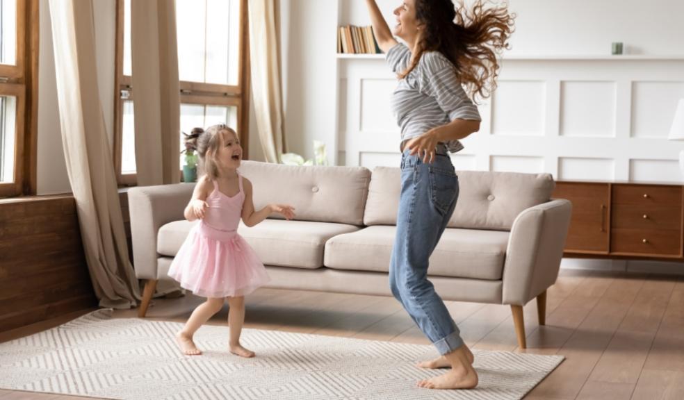 picture of a happy healthy mum dancing with her daughter in the living room