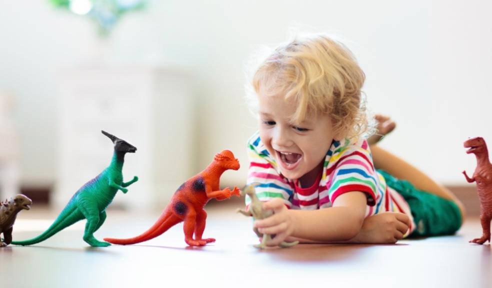 a happy toddler playing with dinosaurs and practising animal sounds picture of a happy toddler playing with dinosaurs and practising animal sounds