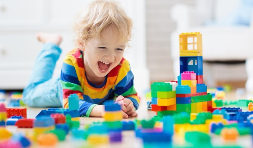 a happy toddler playing with lots of colourful building blocks picture of a happy toddler playing with lots of colourful building blocks
