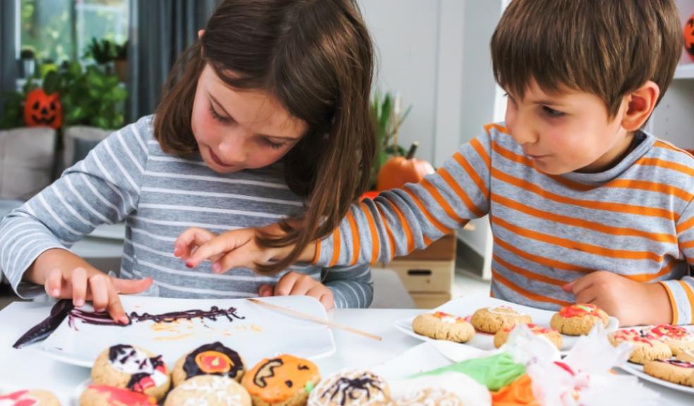 two children baking some autumn themed cookies as a screen free activity idea image of two children baking some autumn themed cookies as a screen free activity idea