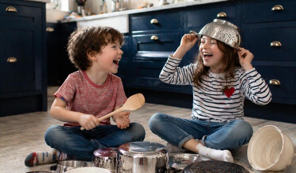 picture of Two children playing music with pots and pans in a kitchen