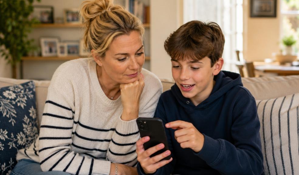 A mum and tween son sitting together on a sofa looking at a smartphone screen picture of A mum and tween son sitting together on a sofa looking at a smartphone screen