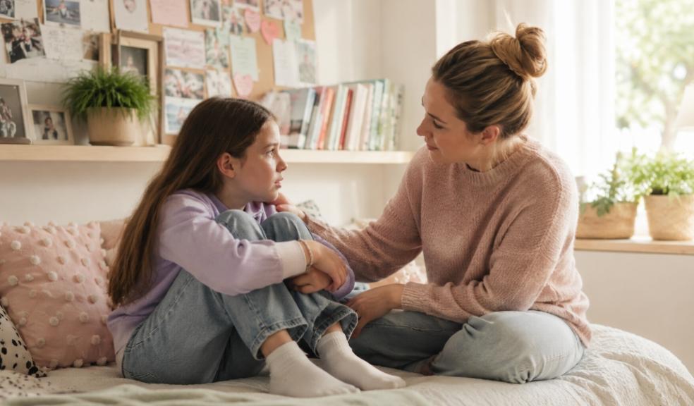 a mum supporting her child with friendship troubles sitting on childs bed picture of a mum supporting her child with friendship troubles sitting on childs bed