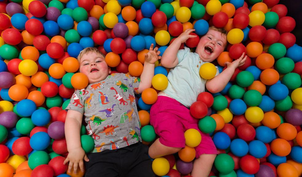 Two children lying in a ball pit at Dinomite Indoor Soft Play at ROARR!