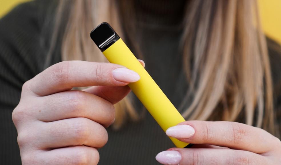 picture of a Girl holding a yellow vape