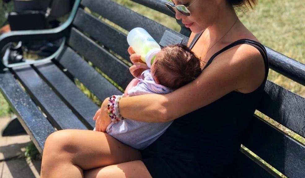 picture of lauren goodger feeding her baby outside on a bench