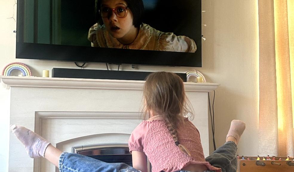 picture of a child doing gymnastics moves on handstand blocks in front of the tv