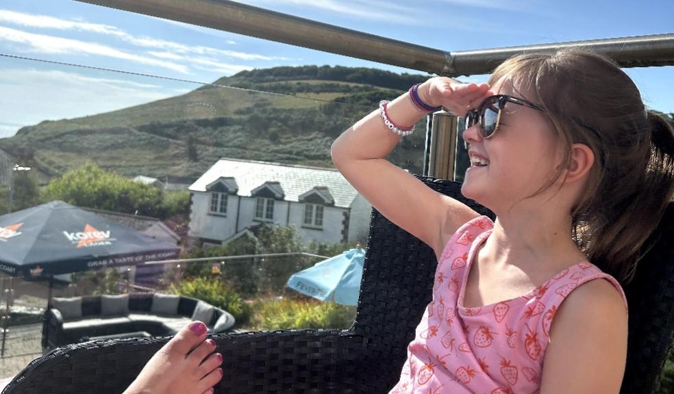 a happy child looking at the view from a balcony at The Llawnroc Hotel Gorran Haven