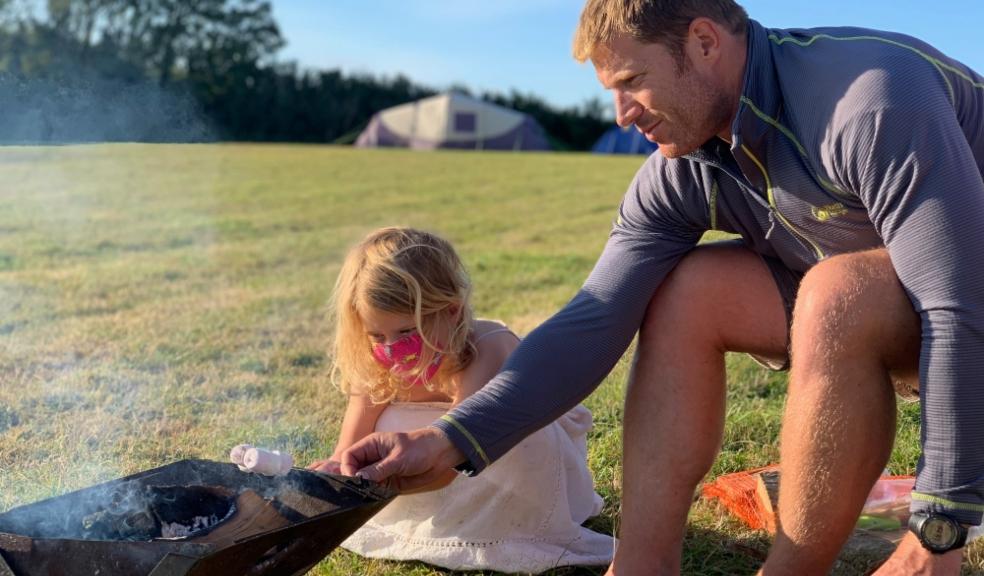 Picture of a father and daughter toasting marshmallows whilst camping