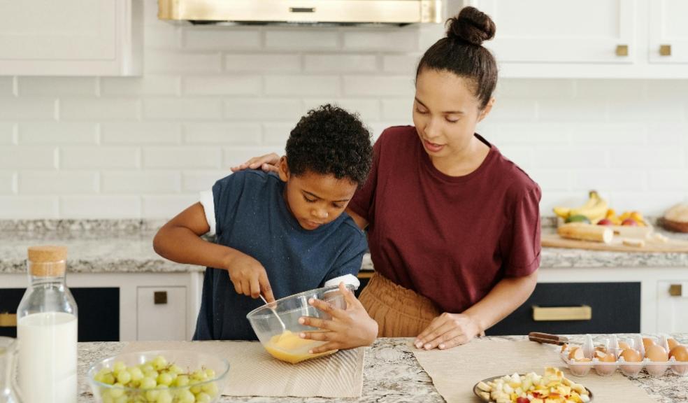 a parent and child cooking together in a kitchen picture of a parent and child cooking together in a kitchen