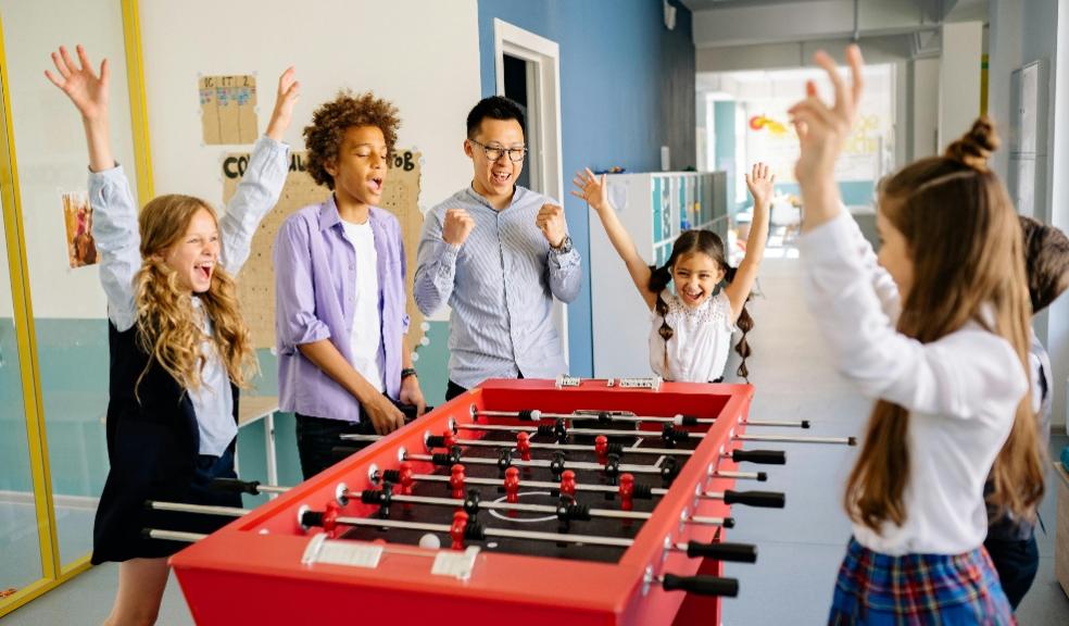 picture of happy children winning a game of table football