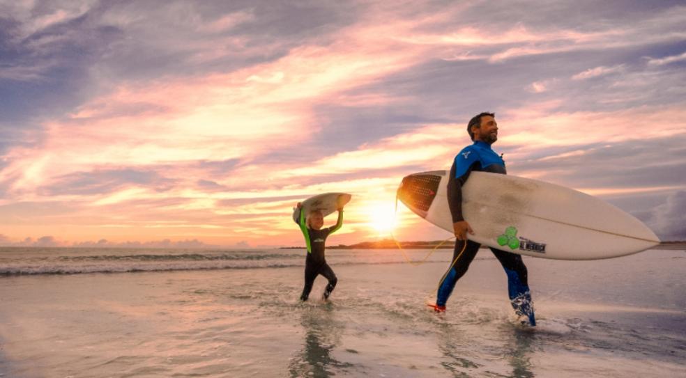 picture of father and son surfing in Guernsey