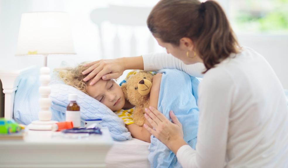 Picture of an unwell child in bed with mum by the bedside