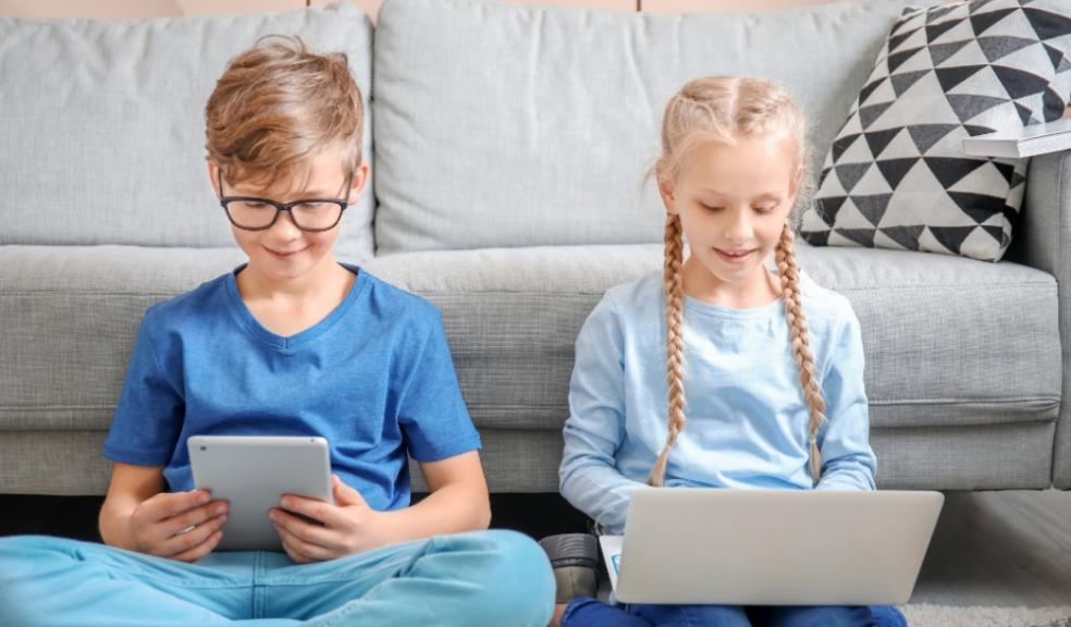 Picture of a boy and girl on an tablet and laptop