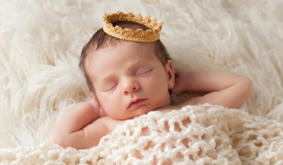 Photo of a newborn baby wearing a crown