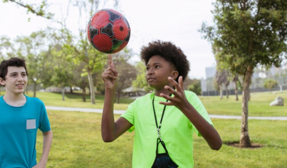 Picture of a child playing football at a summer school