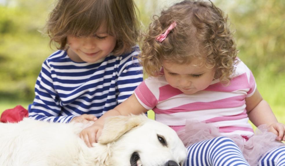 Picture of two young children stroking their pet dog