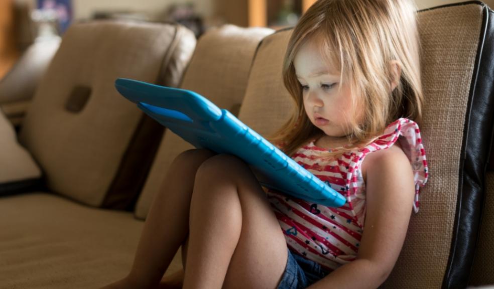 picture of a toddler sat on an ipad