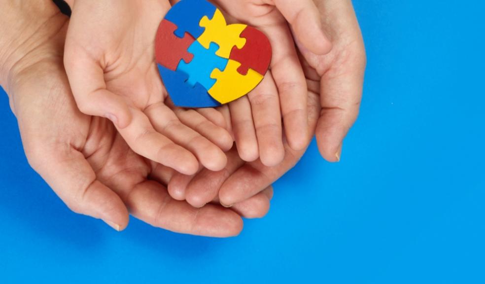 picture of an adult and childs hands holding a jigsaw puzzle heart