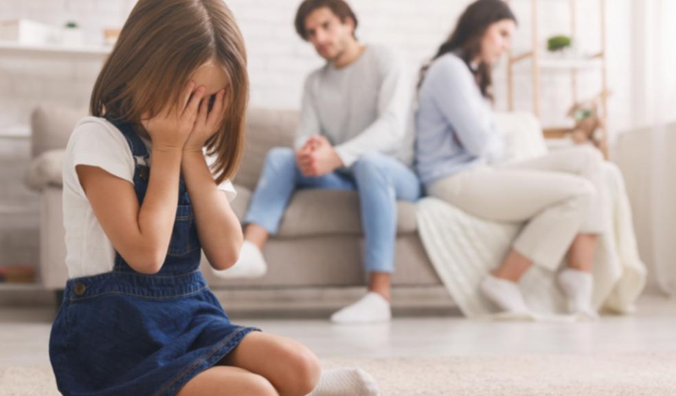 picture of upset child sat in front of arguing parents