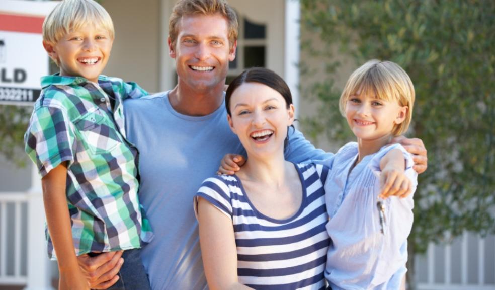 picture of a happy family outside their home