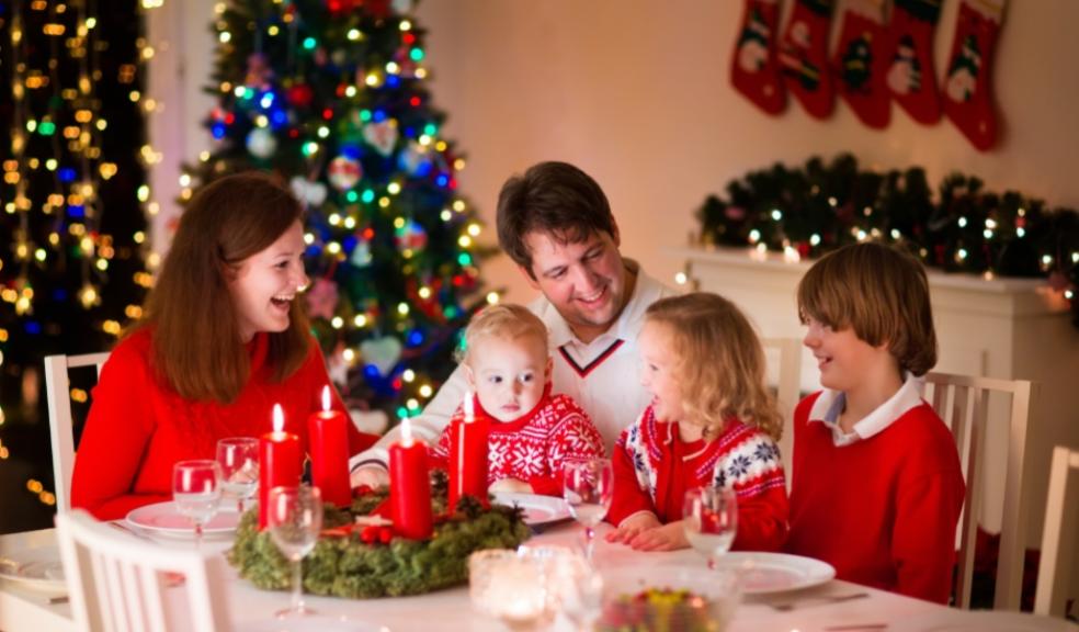picture of happy family around christmas table with candles and christmas lights