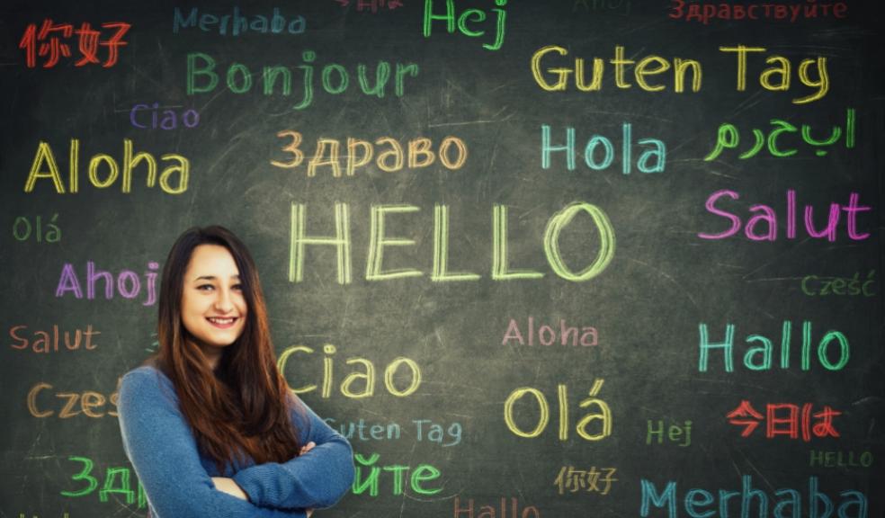 picture of a girl stood in front of a chalkboard with hello written in lots of different languages