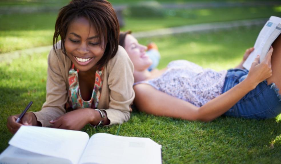 picture of two girls revising for exams out on the grass