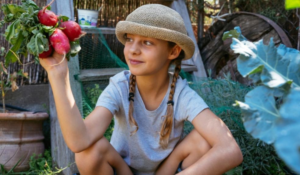 picture of a child sat in an eco friendly garden