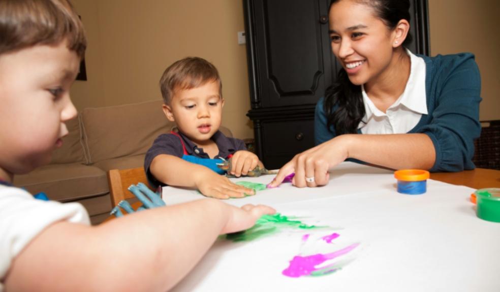 picture of a childcare working painting with children