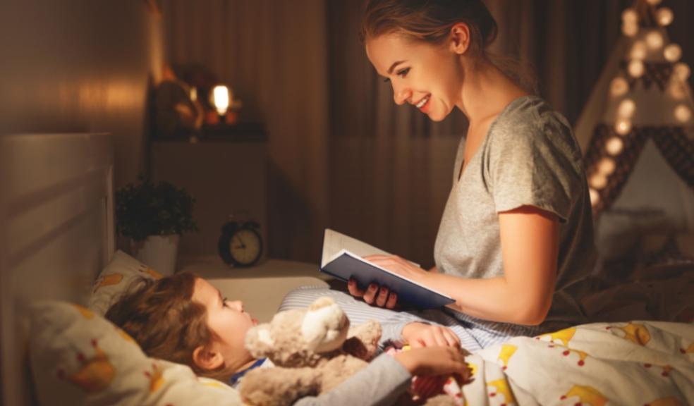picture of a mum reading a child a bedtime story on a bed