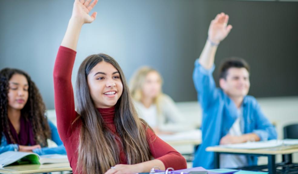 picture of smart students with their hands up 