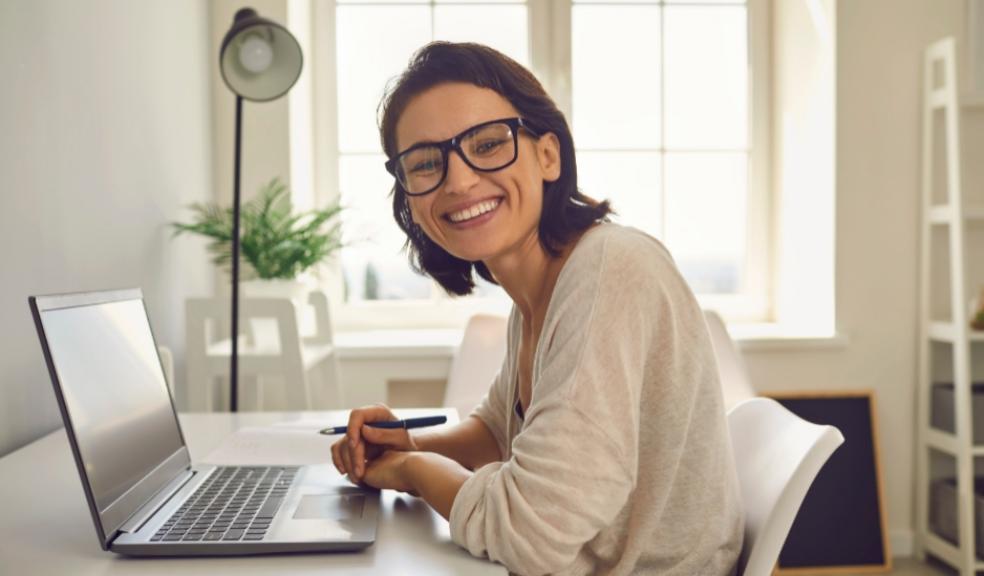 picture of happy woman sat at a laptop