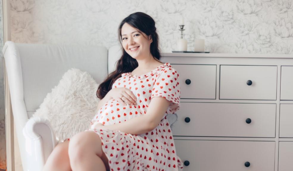 picture of a happy pregnant woman holding her baby bump