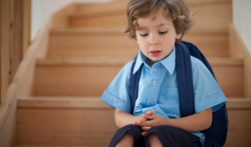 picture of a young boy sitting on the stairs in school uniform